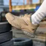 Compact black safety trainers with steel toe, slip-resistant sole, and breathable mesh lining.12